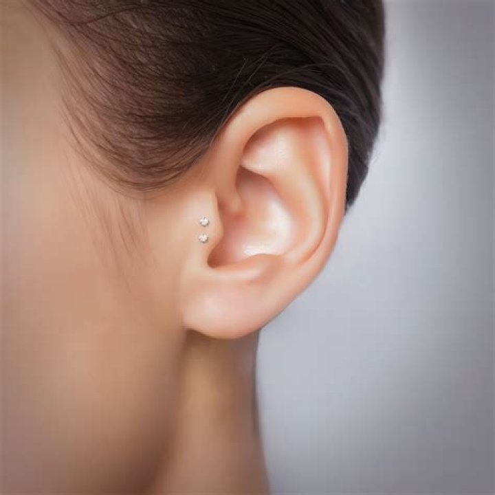 Tragus piercing with a stud earring (L) and in a love shaped earing (R) Tragus piercing with a stud earring (L) and in a love shaped earing (R)